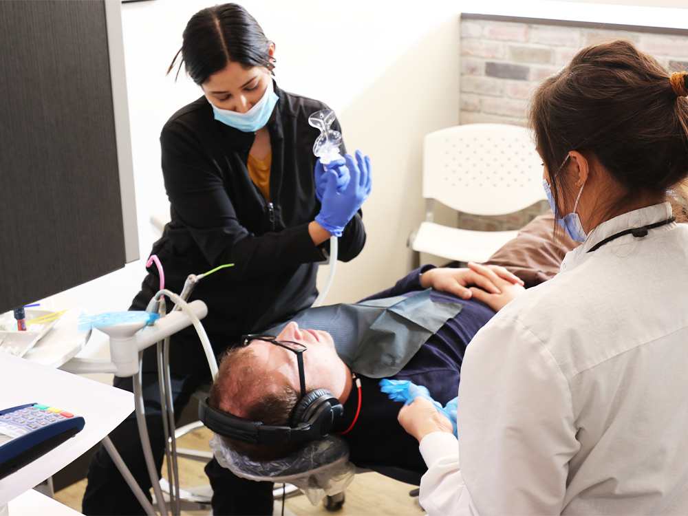 dentist and hygienist talking to patient in chair