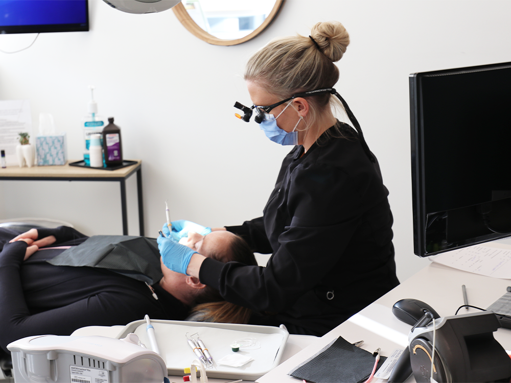 dental hygienist checking patients teeth