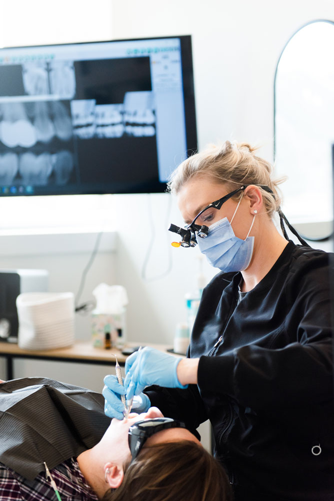 dental hygienist cleaning patients teeth