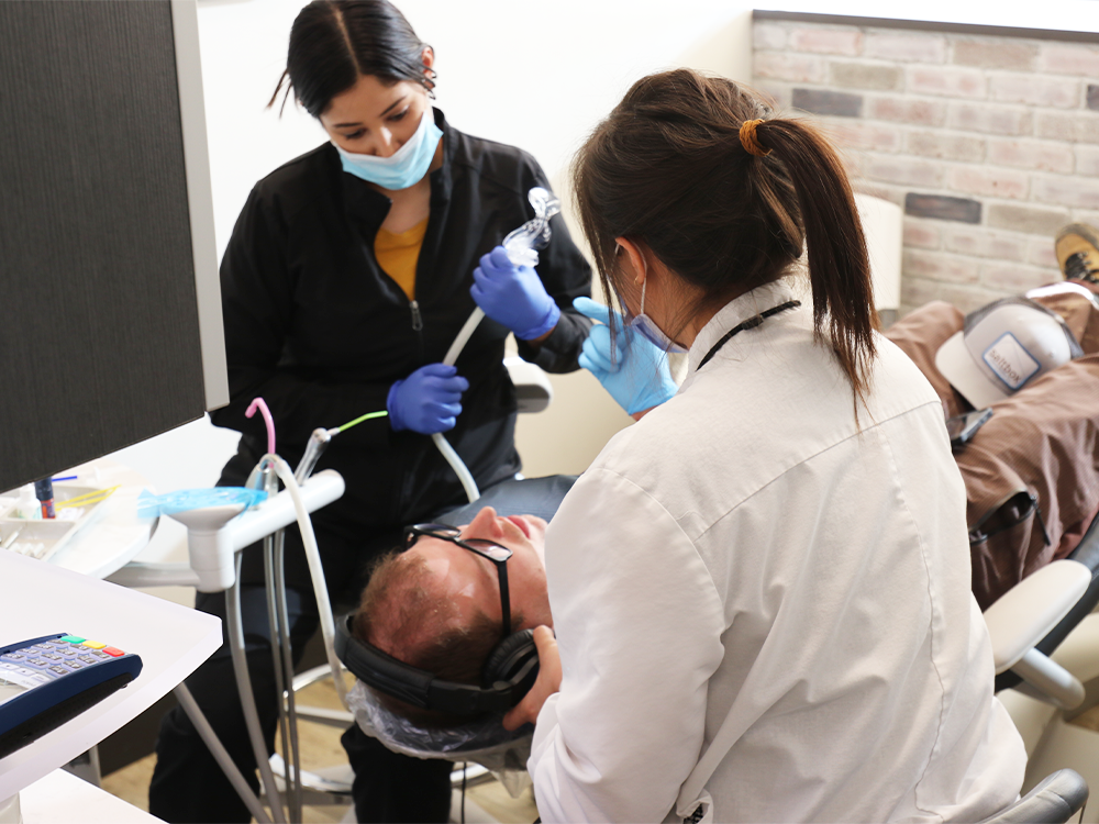 dentist and hygienist talking to patient in chair