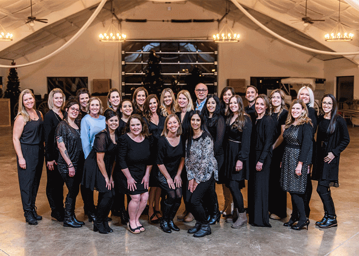 Group photo of the entire Avon Dental staff, around 20 people, dressed in nice clothes.